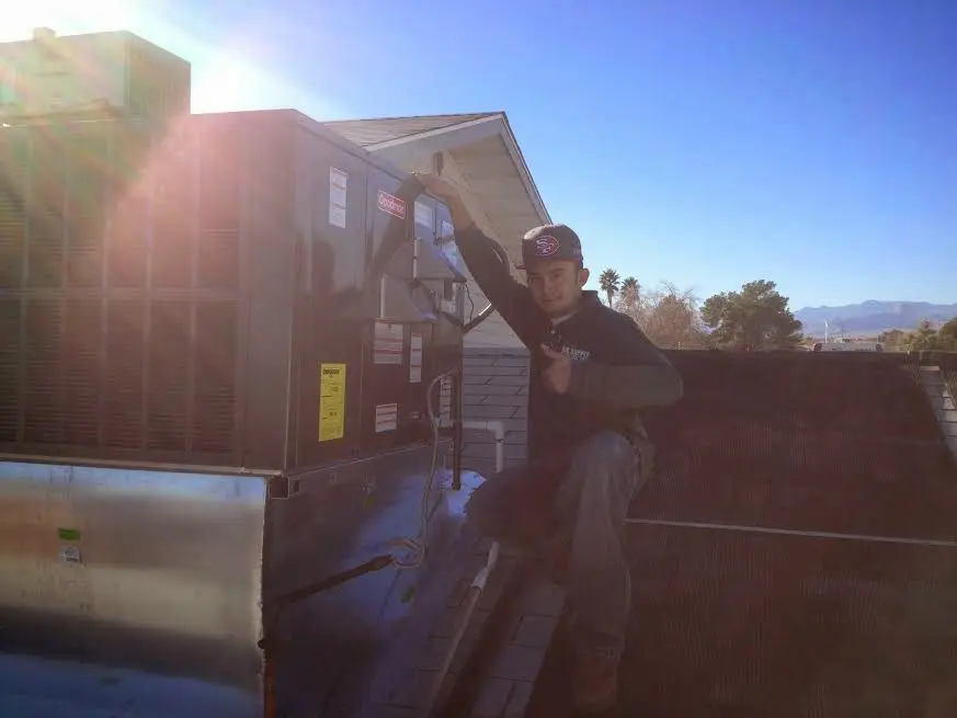 HVAC technician performing Air Duct Cleaning on a rooftop unit in Appleton